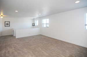 Unfurnished room featuring light carpet, recessed lighting, and baseboards