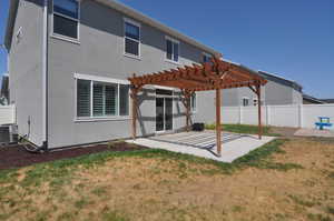 Rear view of property featuring a patio area, a pergola, and stucco siding