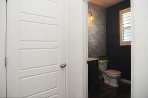 Bathroom with vanity, toilet, and wood finished floors