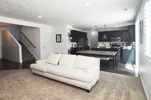 Living room with stairs, baseboards, recessed lighting, and wood finished floors