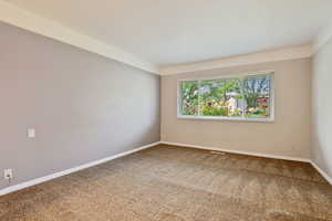 Carpeted empty room with baseboards