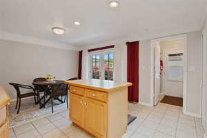 Kitchen featuring light tile patterned floors, light brown cabinetry, a center island, recessed lighting, and light countertops