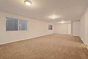 Unfurnished room featuring light colored carpet and baseboards