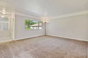 Unfurnished room with light colored carpet and baseboards