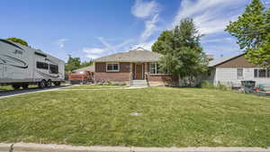 View of front of property featuring brick siding and a front yard