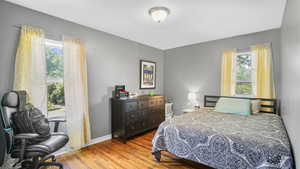 Bedroom with wood finished floors and baseboards