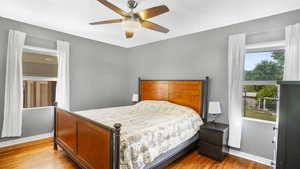 Bedroom featuring baseboards, wood finished floors, and a ceiling fan