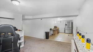 Rec room with light carpet, a textured ceiling, and light tile patterned floors