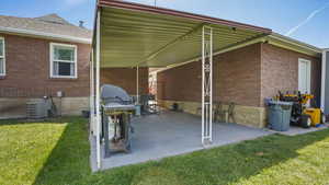 View of patio with cooling unit and a grill