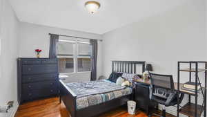 Bedroom featuring wood finished floors and baseboards