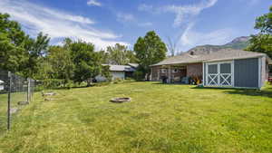 View of yard featuring an outdoor fire pit and a mountain view