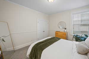 Bedroom featuring carpet floors, ornamental molding, and baseboards