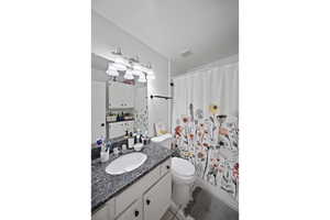 Bathroom featuring vanity, toilet, and tile patterned floors