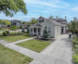 View of front of house with a porch, stucco siding, and roof with shingles