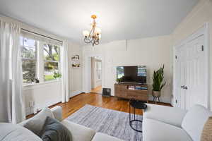 Apartment #88.  Living area featuring a chandelier, baseboards, and wood finished floors