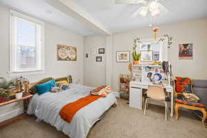 Carpeted bedroom featuring a ceiling fan