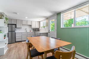 Dining room with a baseboard heating unit, light wood-style floors, and a baseboard radiator