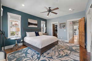 Bedroom with baseboards, wood finished floors, a spacious closet, recessed lighting, and ceiling fan
