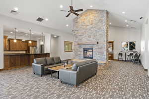 Living room with high vaulted ceiling, a ceiling fan, carpet flooring, a fireplace, and recessed lighting