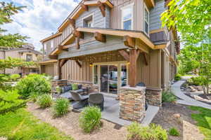 Back of house featuring board and batten siding, an outdoor hangout area, and a patio