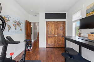 Office area featuring dark wood-type flooring and baseboards