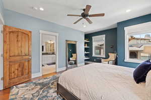 Bedroom with dark wood-type flooring, ensuite bath, recessed lighting, baseboards, and ceiling fan