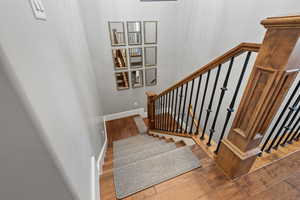 Staircase with wood finished floors and baseboards
