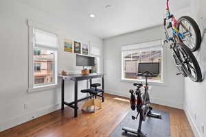 Exercise room featuring healthy amount of natural light, wood finished floors, baseboards, and recessed lighting