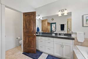 Full bathroom featuring vanity, tile patterned floors, a garden tub, a shower stall, and toilet