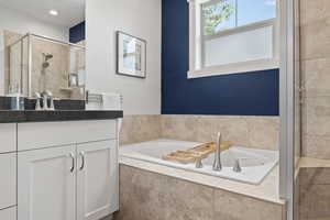 Full bathroom with vanity, a garden tub, and a shower stall