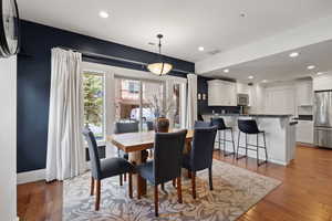 Dining room with light wood finished floors and recessed lighting