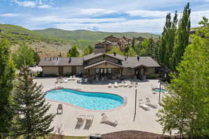 Community pool with a patio area and a mountain view