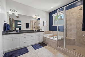 Full bathroom with a shower stall, double vanity, tile patterned flooring, and a garden tub