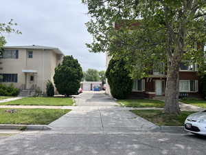 View of front facade featuring a front lawn, a detached garage, and stucco siding