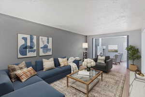 Virtually staged  Living room featuring a textured ceiling