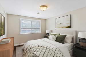 Virtually staged  Bedroom with wood finished floors and baseboards