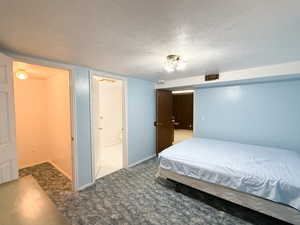 Bedroom featuring carpet and a textured ceiling
