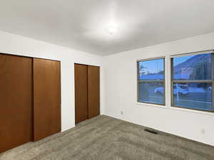 Unfurnished bedroom with multiple closets and carpet floors