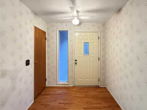 Entryway with light wood-style floors, a ceiling fan, and baseboards