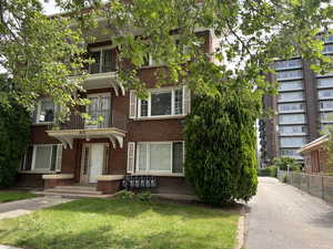 View of front of home featuring a balcony and brick siding