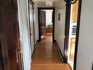 Hallway with light wood finished floors and baseboards