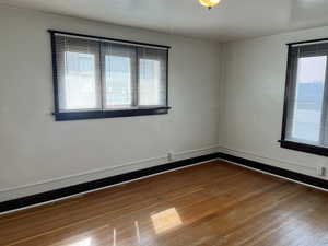 Empty room with hardwood / wood-style flooring and baseboards