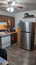 Kitchen with appliances with stainless steel finishes, ceiling fan, under cabinet range hood, and dark wood finished floors