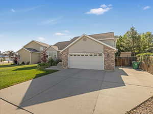 Traditional home featuring concrete driveway, brick siding, an attached garage, and stucco siding