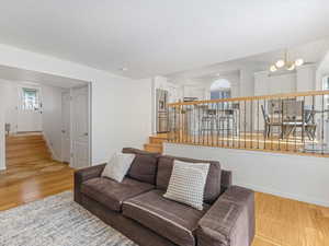 Living area with stairway, light wood-type flooring, and baseboards