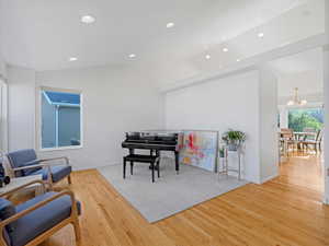 Living area with wood finished floors, recessed lighting, baseboards, and vaulted ceiling