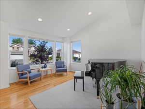 Living area with wood finished floors, vaulted ceiling, recessed lighting, and baseboards