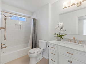 Bathroom featuring tile patterned floors, vanity, toilet, and shower / tub combo with curtain