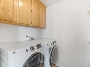 Washroom featuring cabinet space and separate washer and dryer