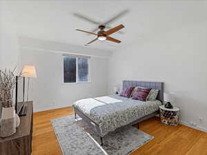 Bedroom featuring wood finished floors, baseboards, and a ceiling fan